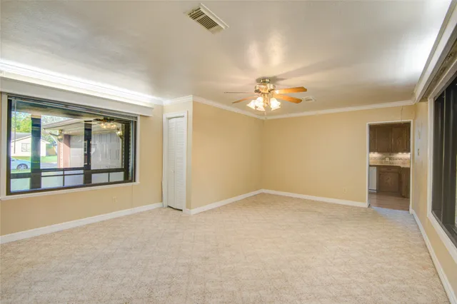 an empty room with chandelier and windows
