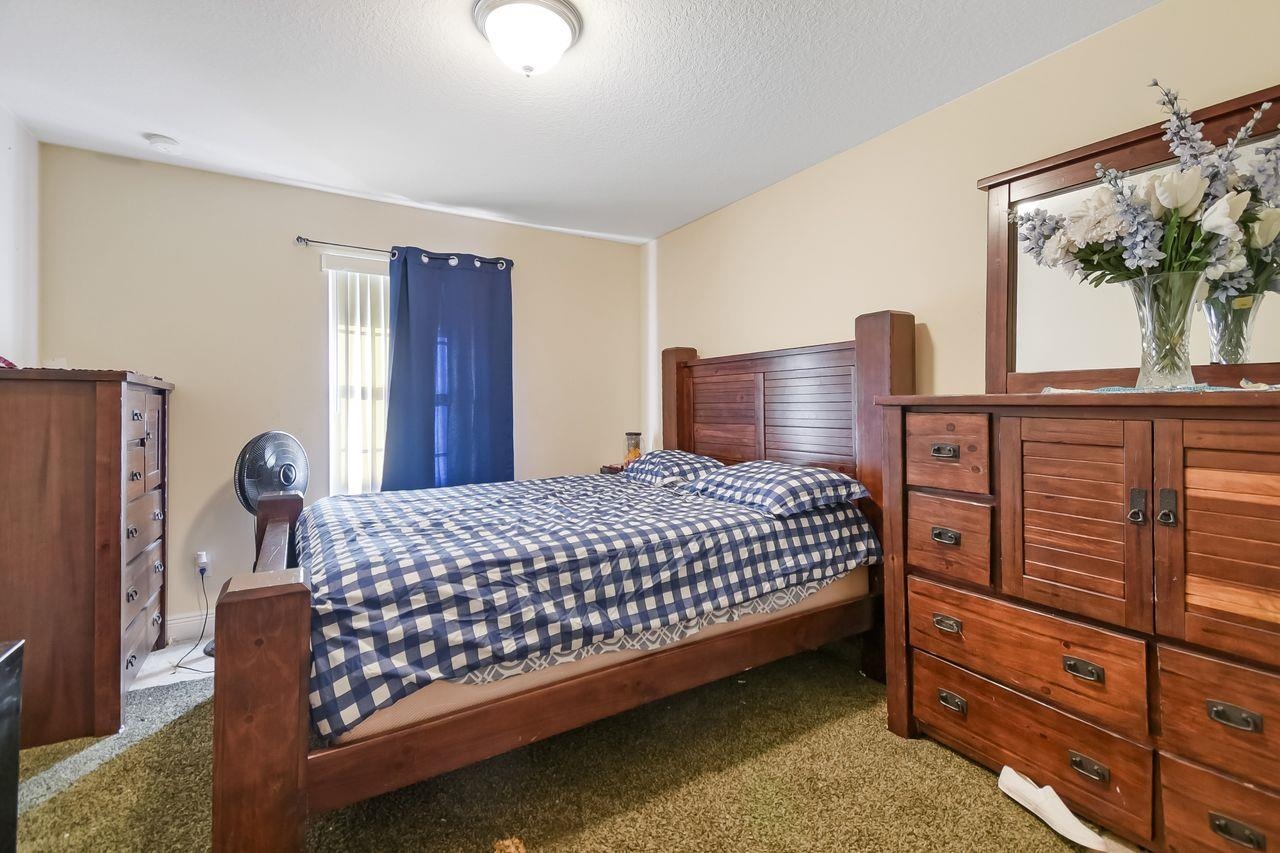 46 Riddle Drive Palm Coast, FL 32164 - Photo 12 of 20 a bed sitting in a bedroom next to a window with dresser