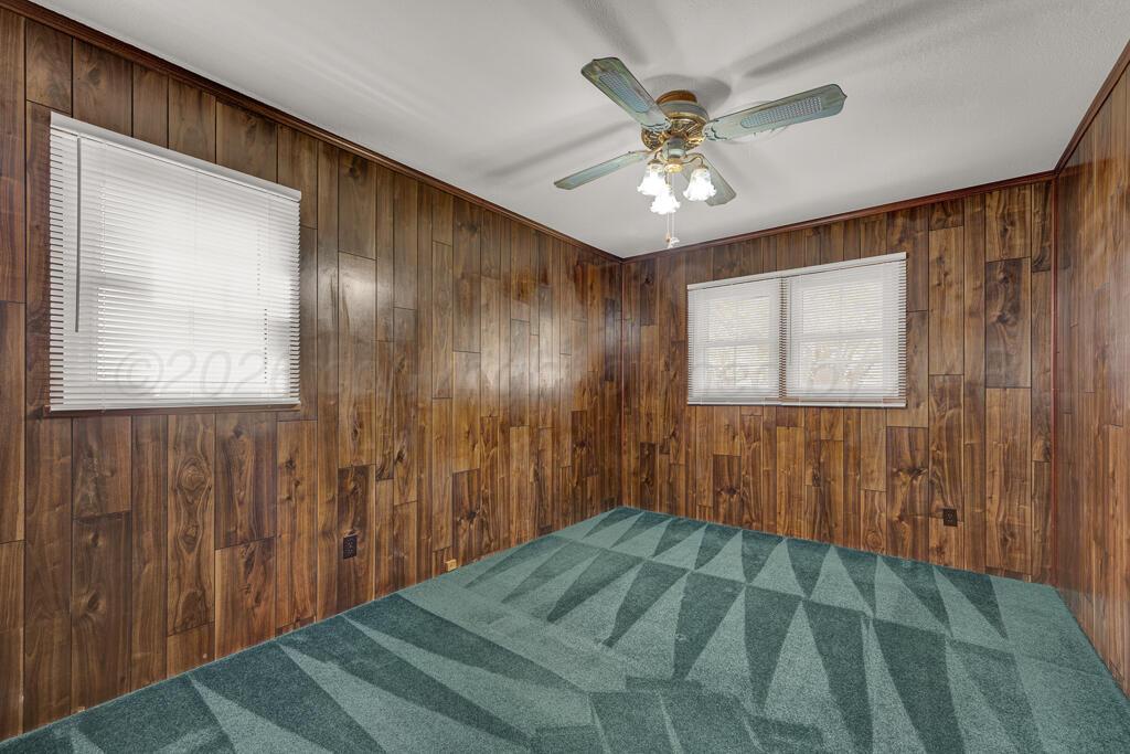 5025 South Crockett Street Amarillo, TX 79110 - Photo 19 of 30 a bedroom with a bed and a chandelier