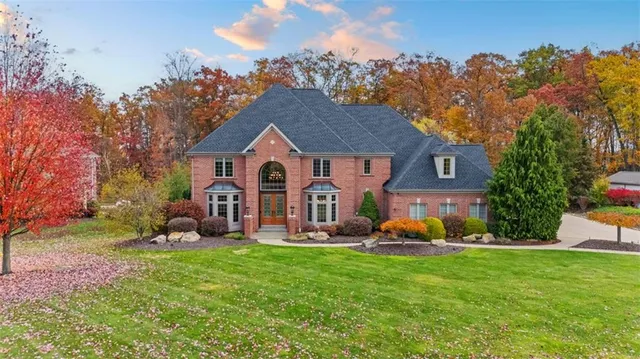 a front view of house with yard and trees in the background