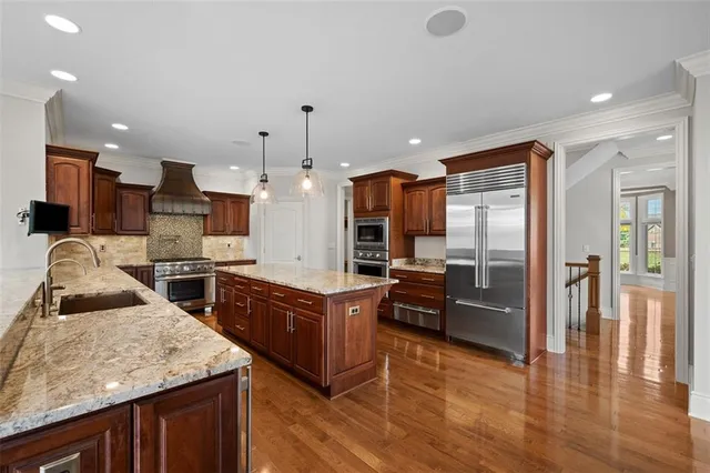 a kitchen with stainless steel appliances granite countertop a refrigerator a oven a sink and dishwasher