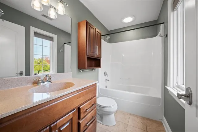 a bathroom with a bathtub shower sink vanity and toilet
