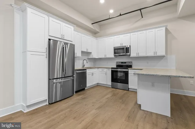 a kitchen with cabinets stainless steel appliances and a window