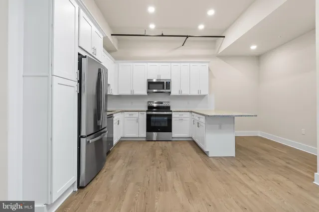 a kitchen with granite countertop a refrigerator oven a sink and dishwasher