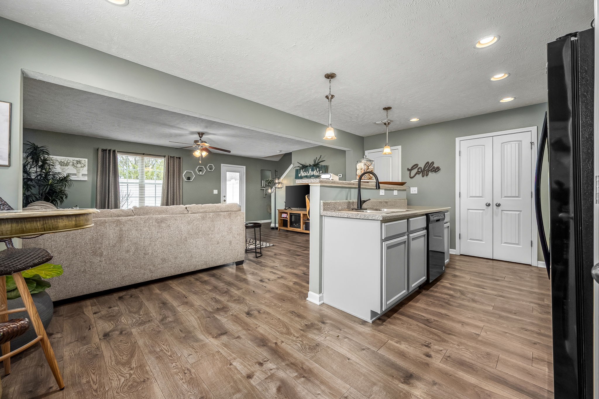 4720 Chelanie Circle Murfreesboro, TN 37129 - Photo 14 of 31 a large white kitchen with kitchen island a stove a sink a refrigerator and white cabinets with wooden floor