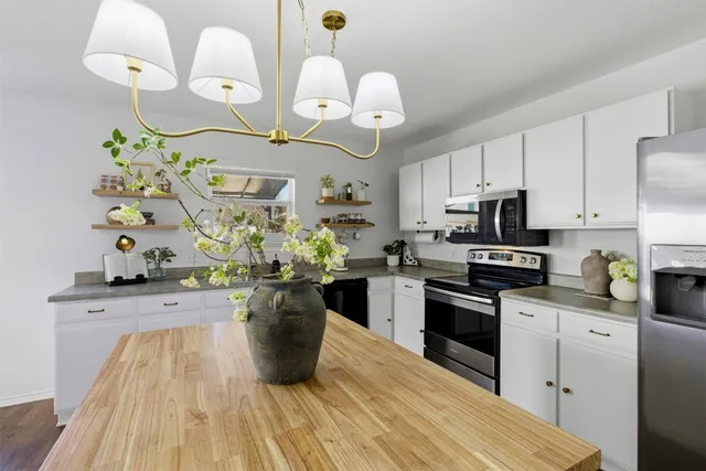 a kitchen with white cabinets and stainless steel appliances