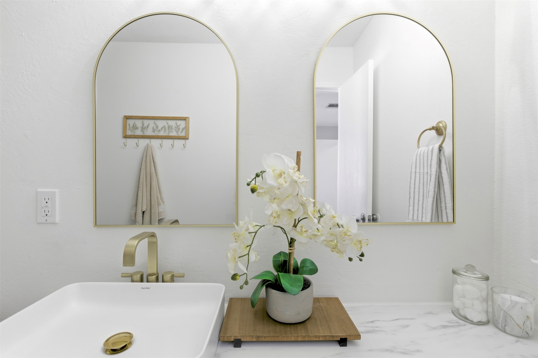 75 Jan Lane Georgetown, TX 78626 - Photo 22 of 32 Updated bathroom featuring a modern vanity, gold-tone fixtures, and dual arched mirrors.