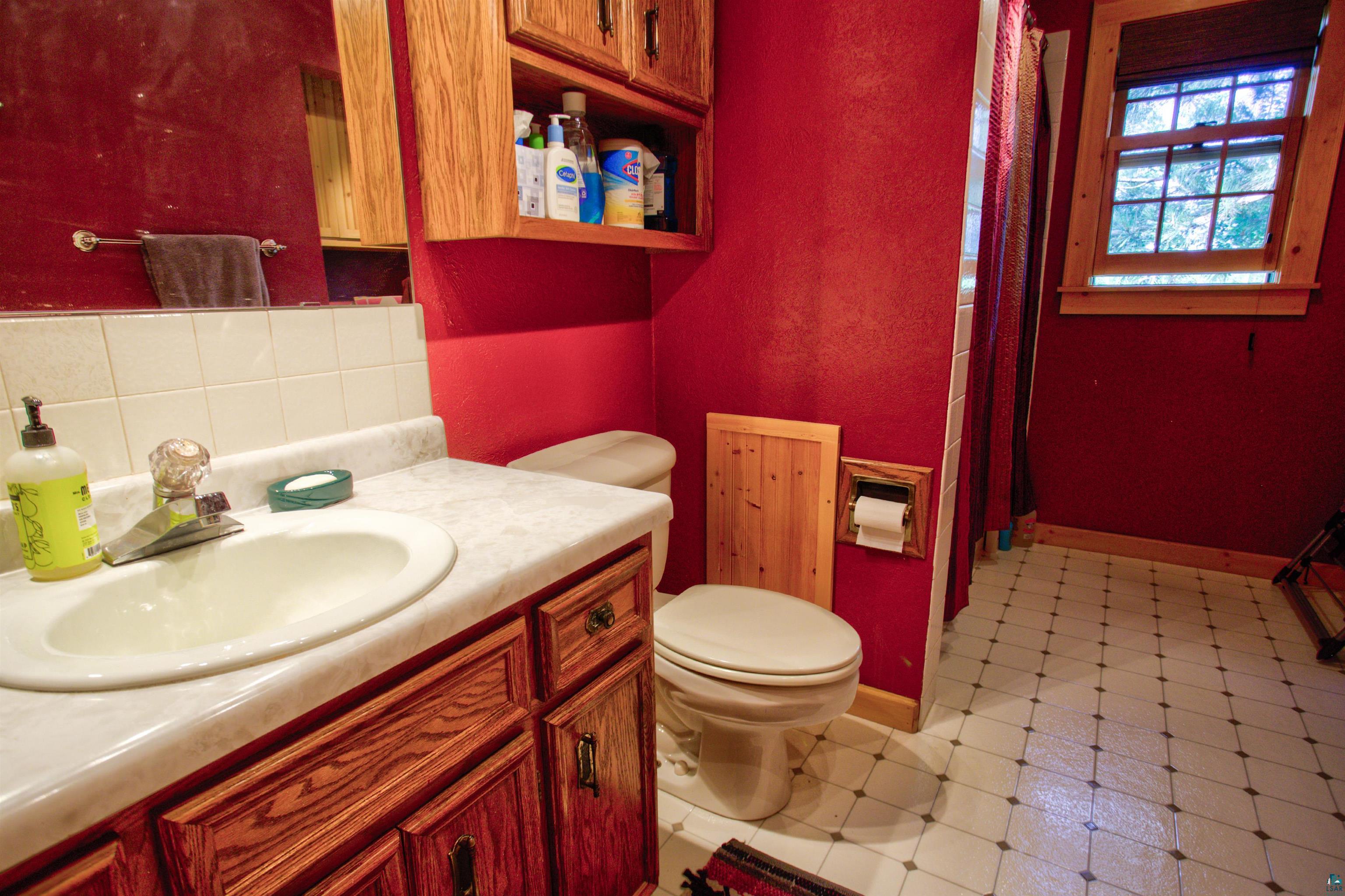 12351 Endless Waters Road Ely, MN 55731 - Photo 27 of 48 Bathroom featuring tasteful backsplash, vanity, a textured wall, tile patterned floors, and curtained shower