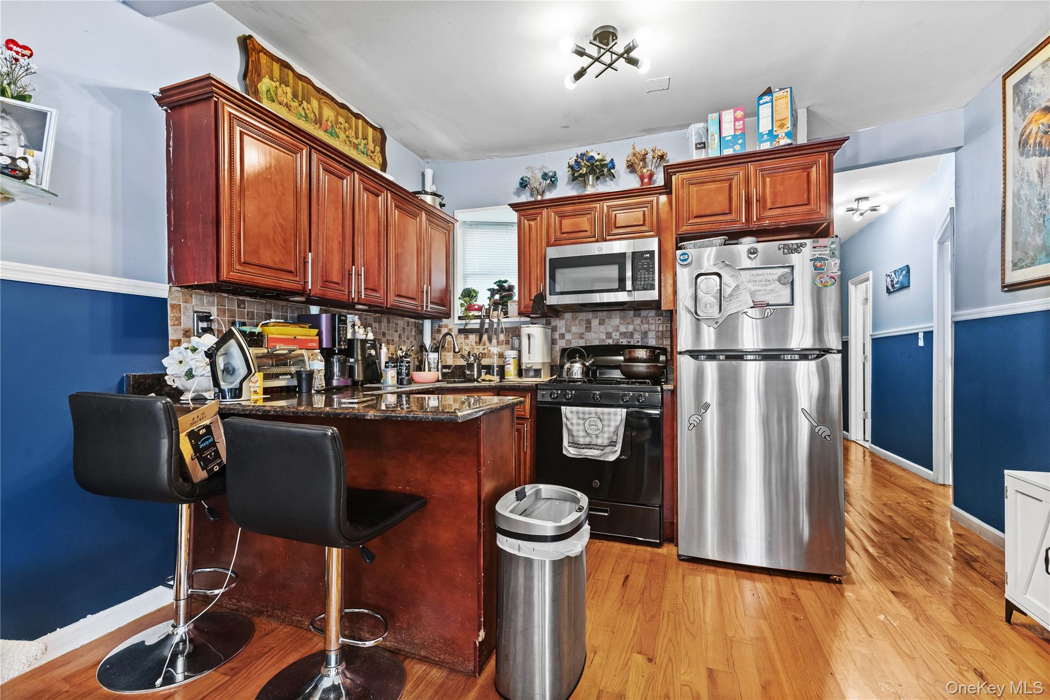 603 East 236th Street Bronx, NY 10466 - Photo 9 of 28 a kitchen with granite countertop a refrigerator a stove and a wooden floors