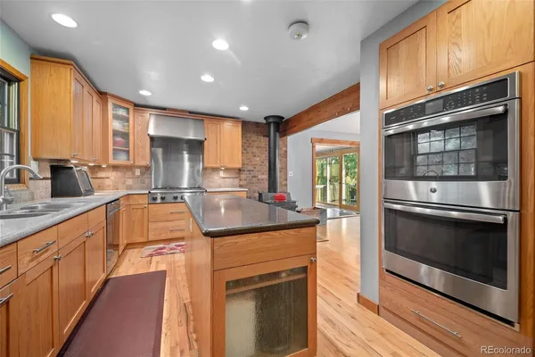 a kitchen with stainless steel appliances granite countertop a stove sink and microwave
