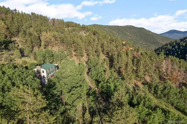 a view of a houses with a lush green hillside