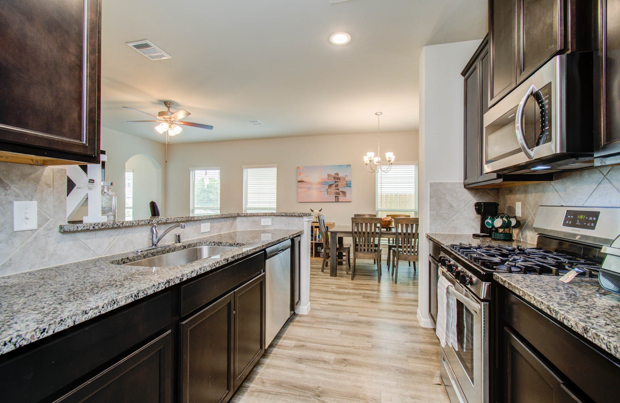 13309 Myrtle Meadows Lane Houston, TX 77048 - Photo 12 of 32 a kitchen with stainless steel appliances granite countertop a stove a sink and a microwave