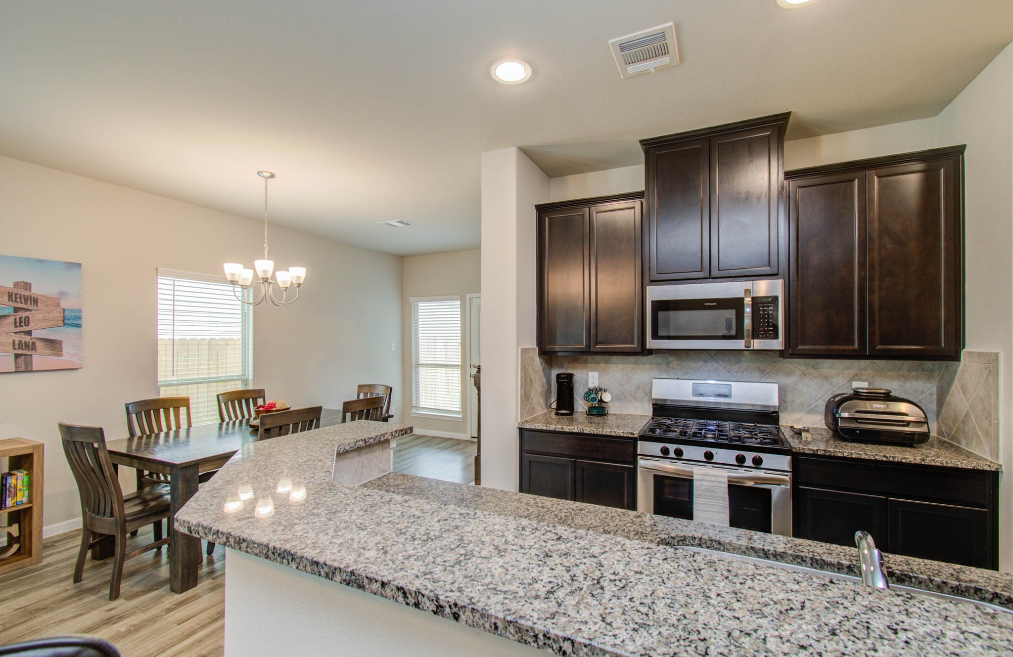 13309 Myrtle Meadows Lane Houston, TX 77048 - Photo 9 of 32 a kitchen with stainless steel appliances granite countertop a stove a sink and a microwave
