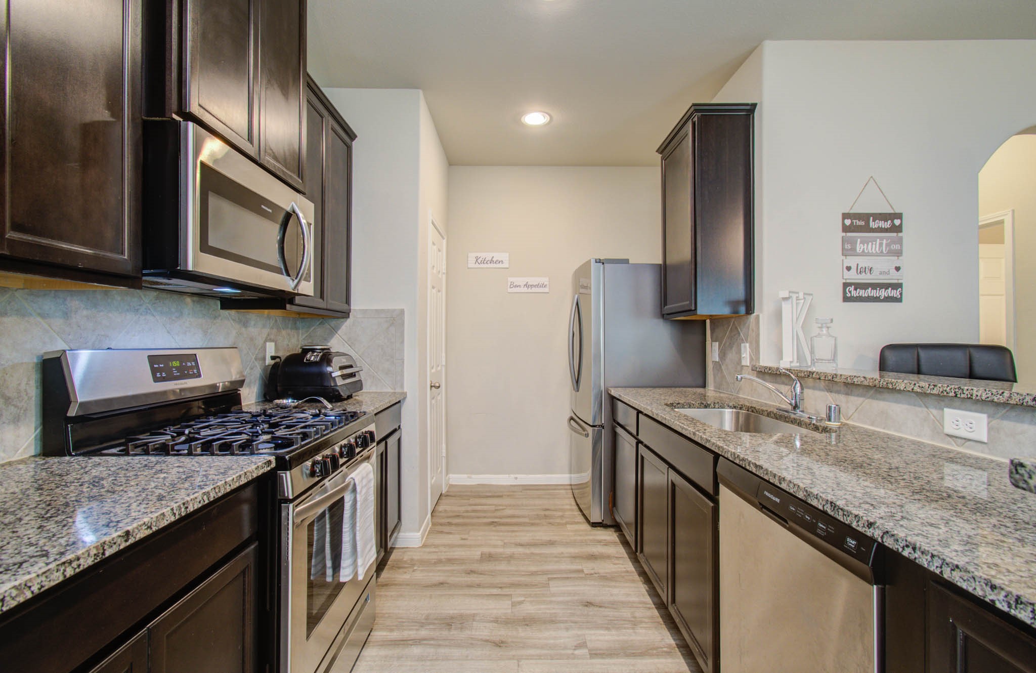 13309 Myrtle Meadows Lane Houston, TX 77048 - Photo 10 of 32 a kitchen with stainless steel appliances granite countertop a sink stove and refrigerator