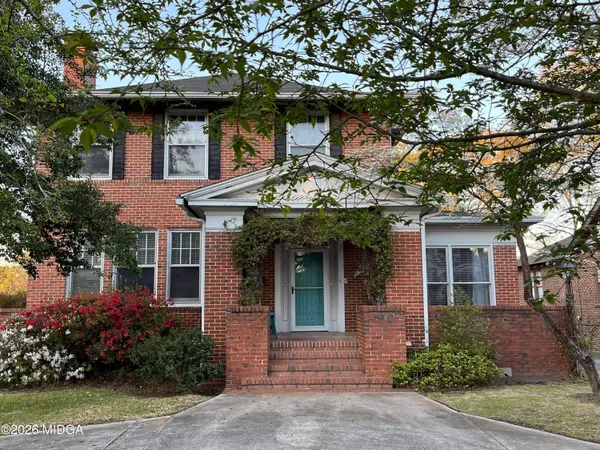a front view of a house with a garden
