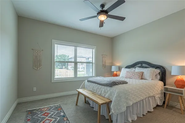 a bathroom with a granite countertop toilet a sink a mirror and a shower