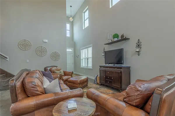 a living room with furniture a flat screen tv and kitchen view