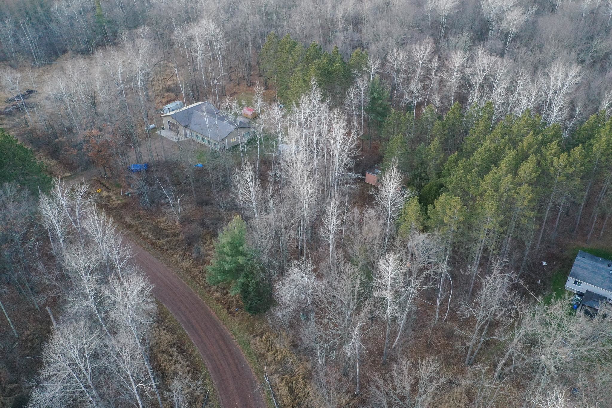 Aerial view of property and surrounding area featuring a heavily wooded area