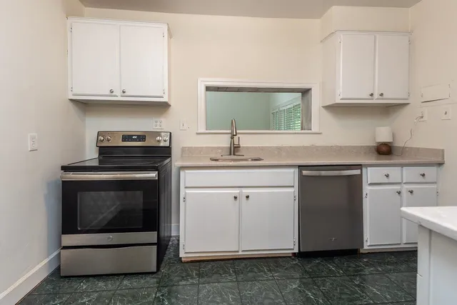 a kitchen with cabinets appliances and a sink