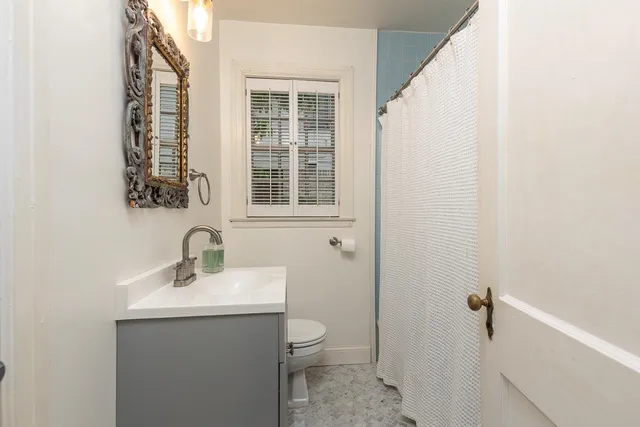 a bathroom with a toilet a sink and a mirror