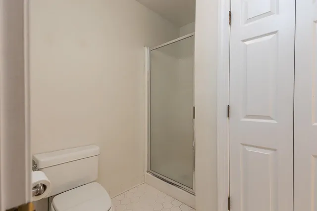 a white toilet sitting next to a shower