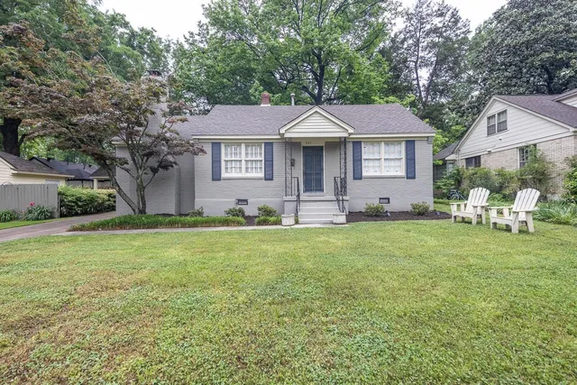 a front view of a house with a garden and yard