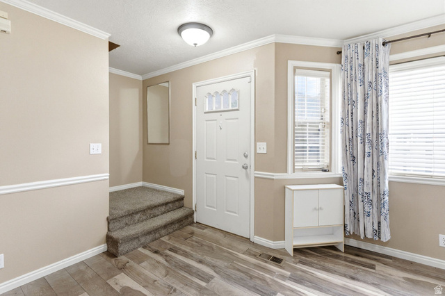 1052 South 950 East, Unit 33 Provo, UT 84606 - Photo 1 of 12 Entrance foyer with ornamental molding, light wood-type flooring, and a textured ceiling