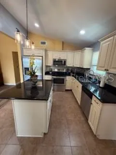 a kitchen with stainless steel appliances granite countertop a sink and a stove
