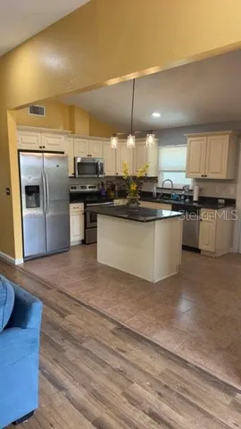 a kitchen with stainless steel appliances granite countertop a sink a stove and a refrigerator