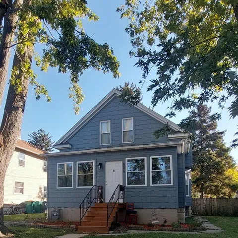 a front view of a house with a tree