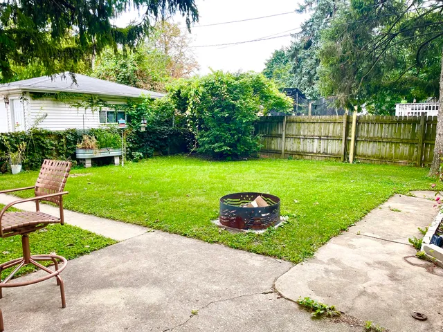 a couple of table and chairs under an umbrella in backyard