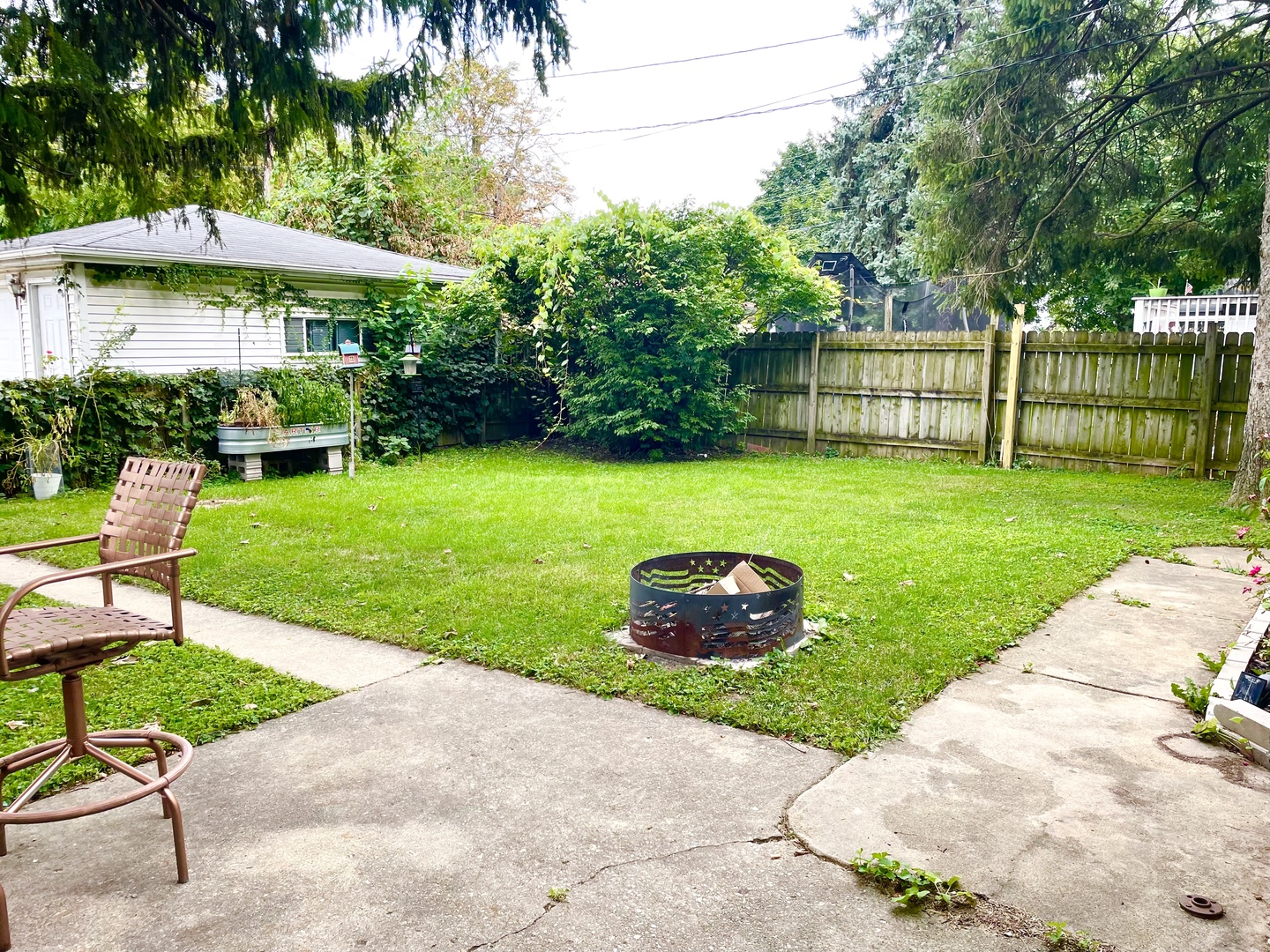 604 Clement Street Joliet, IL 60435 - Photo 12 of 14 a couple of table and chairs under an umbrella in backyard