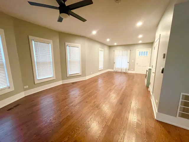 a view of a livingroom with a window and wooden floor