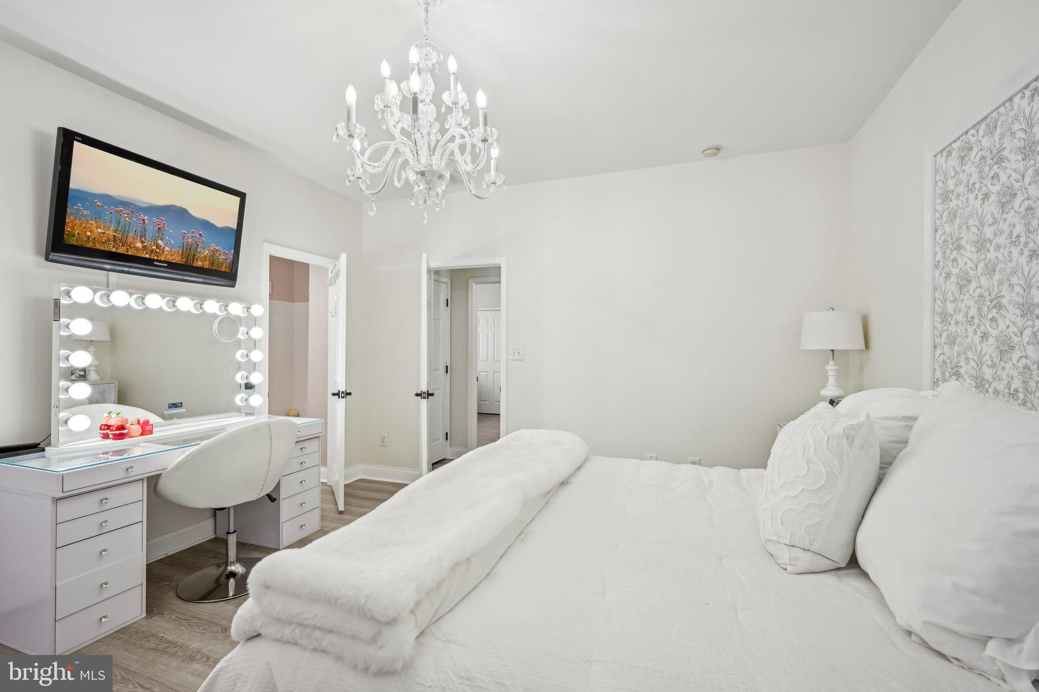 13 Carriage Berlin, NJ 08009 - Photo 24 of 41 a bedroom with a bed and a chandelier
