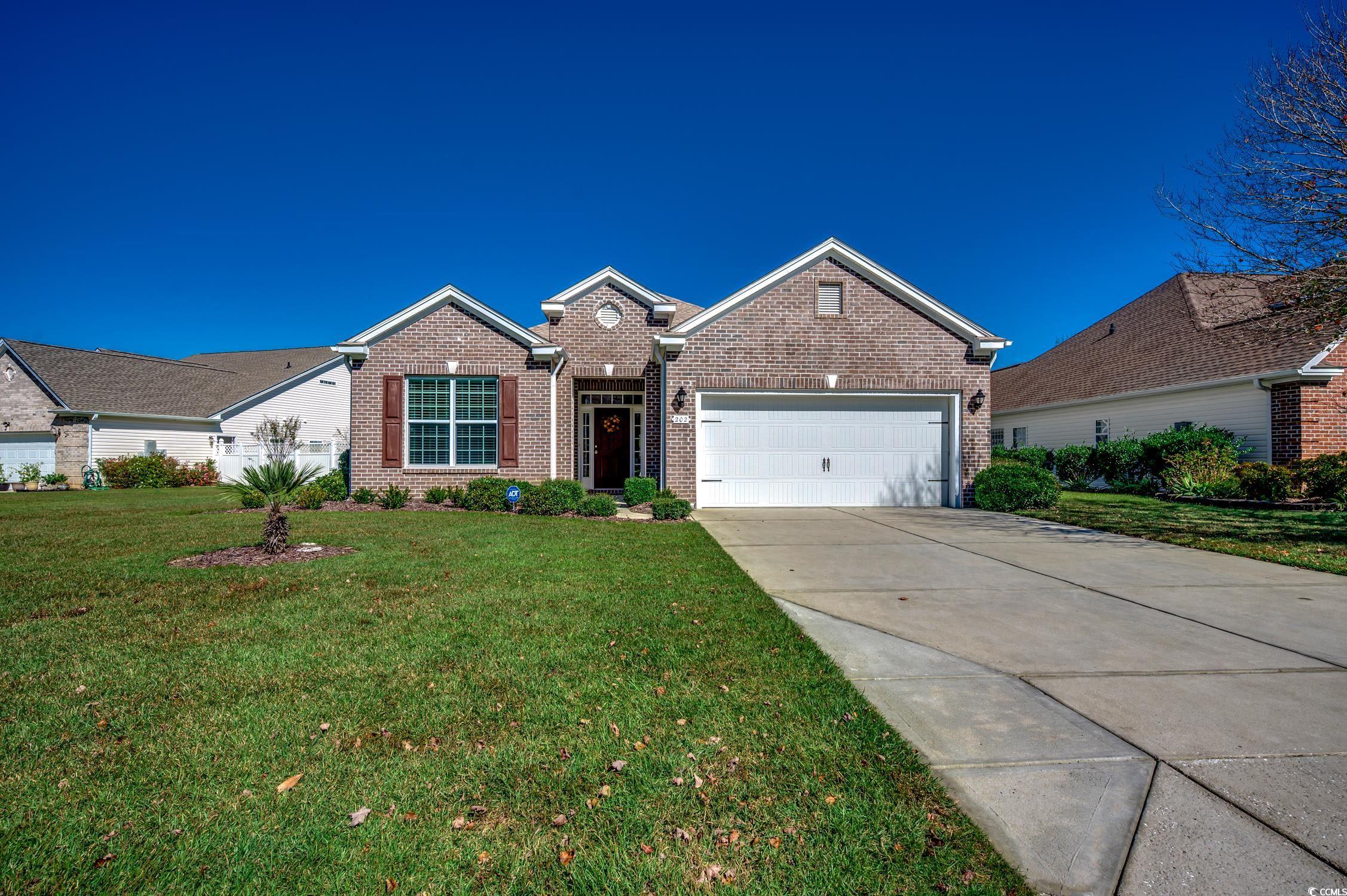 202 Fox Den Drive Murrells Inlet, SC 29576 - Photo 2 of 35 View of front facade featuring brick siding, concrete driveway, a front yard, and an attached garage