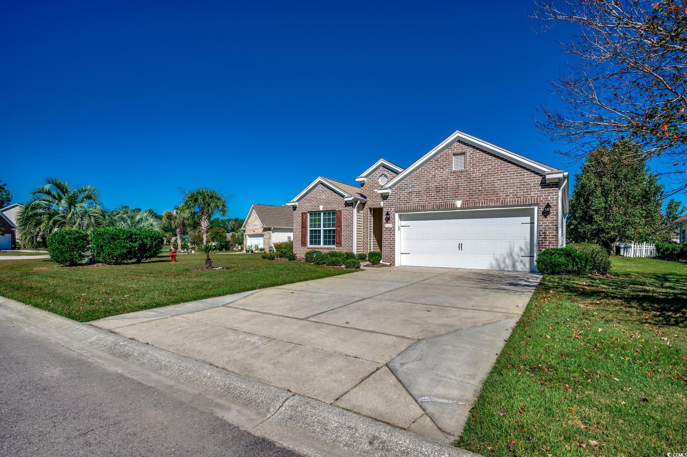 202 Fox Den Drive Murrells Inlet, SC 29576 - Photo 3 of 35 View of front facade with a front lawn, concrete driveway, brick siding, and a garage