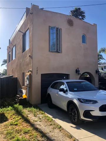 a front view of a house with a garden and trees