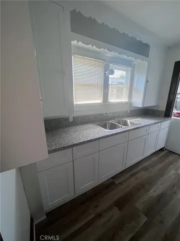 a bathroom with a granite countertop sink a toilet a mirror and vanity