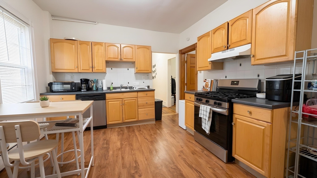 26 Darling Street, Unit 2 Boston, MA 02120 - Photo 2 of 15 a kitchen with stainless steel appliances kitchen island granite countertop a stove a sink and a refrigerator