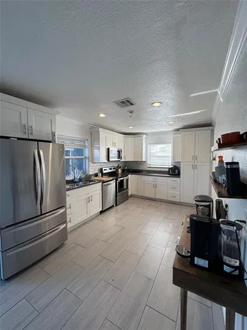 a kitchen with a refrigerator and a stove top oven