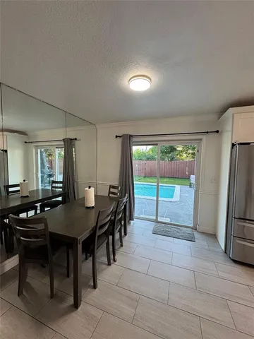 a kitchen with a table chairs and a refrigerator