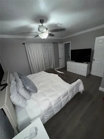 a bedroom with a bed window and a flat screen tv