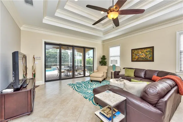 a living room with furniture ceiling fan and a flat screen tv