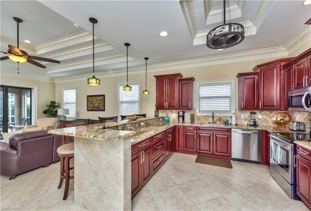 a kitchen with stainless steel appliances granite countertop a stove a sink dishwasher and a refrigerator with wooden cabinets