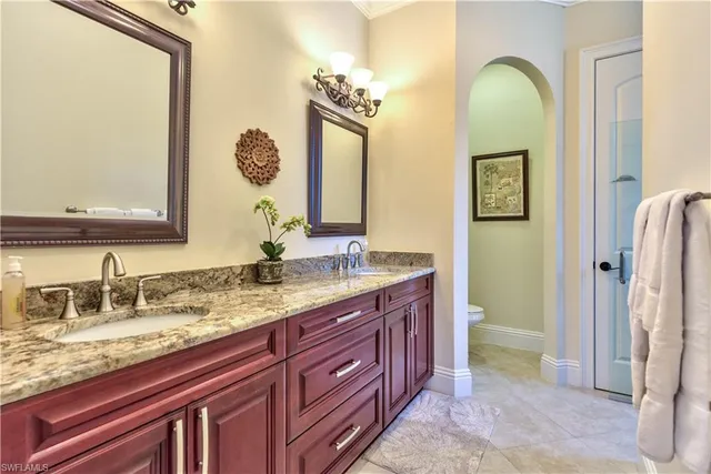 a bathroom with a granite countertop sink a toilet and a mirror