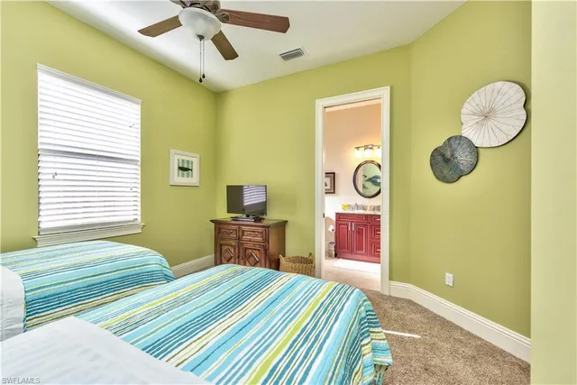 a bedroom with a bed and dresser with wooden floor