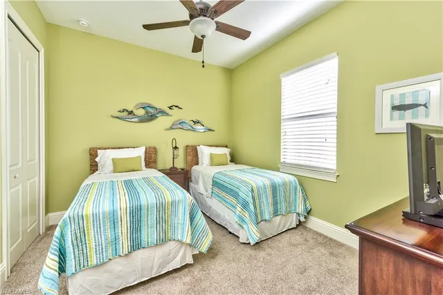 a bedroom with two beds and a flat screen tv