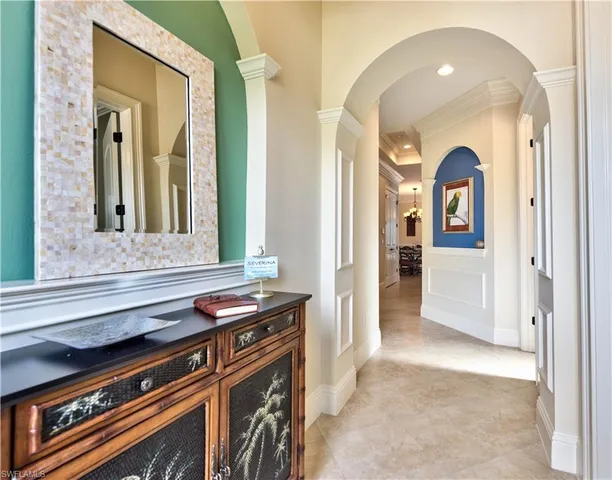 a view of a hallway of a livingroom with furniture and window