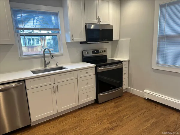 a kitchen with stainless steel appliances granite countertop a stove a sink and a microwave