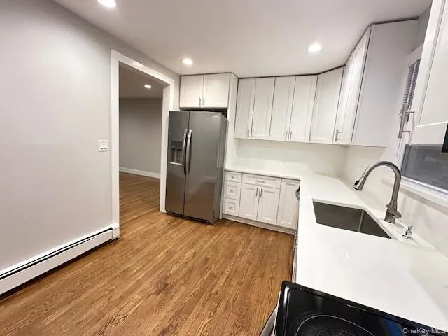 a kitchen with granite countertop a refrigerator and a sink